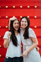 beautiful asian girl smling at camera at red door.