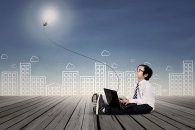 asian kid with business clothing working on laptop. background is scribble of cityscape