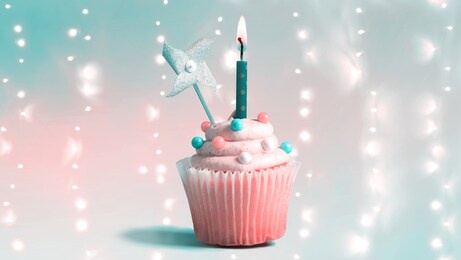 celebratory cupcake with a decorative lit candle