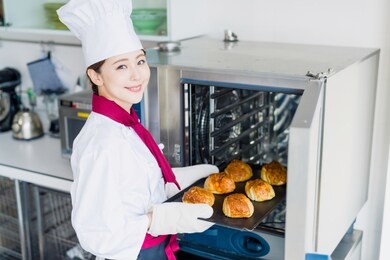 young female baker baking breads.