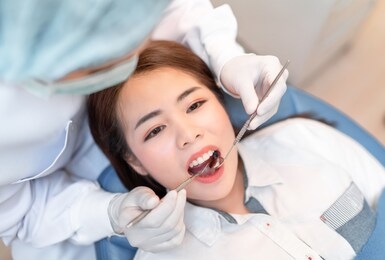 closeup woman having dental teeth examined dentist check-up via excavator in clinic her patient for beautiful smile