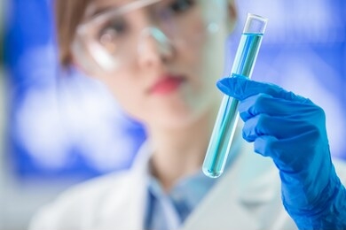 asian female scientist hold a test tube filled with liquid in the laboratory