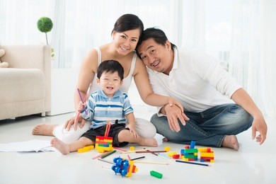 portrait of parents playing with his son in lego constructions at home