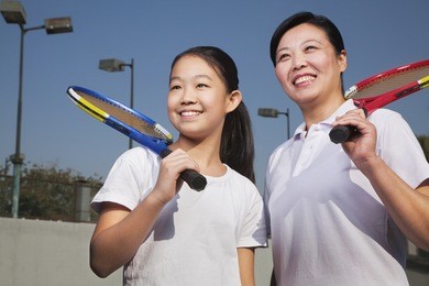 mother and daughter playing tennis