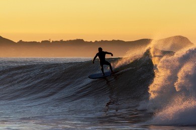 dawn surfing, with quality waves and stunning morning. location new zealand, kaikoura at the kahutara surf break.