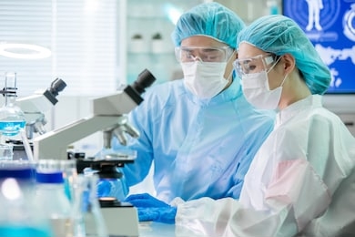 asian biotechnology research team look computer and meeting with cleanroom clothes in the factory