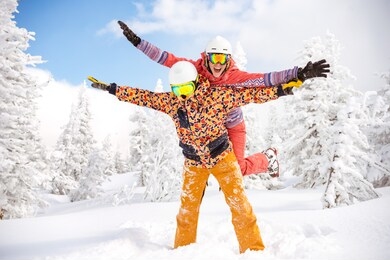 happy couple skier and snowboarder are having fun at ski resort. ski winter sports concept