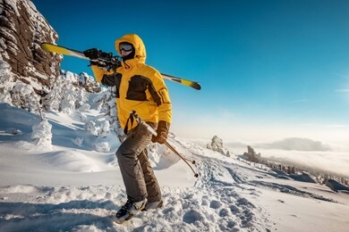 skier with ski in hands goes uphill for backcountry skiing. ski resort concept