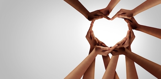 unity and diversity partnership as heart hands in a group of diverse people connected together shaped as a support symbol expressing the feeling of teamwork and togetherness.