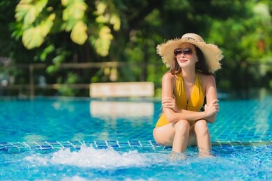 portrait beautiful young asian woman leisure relax smile and happy around swimming pool in hotel resort for holiday vacation trip