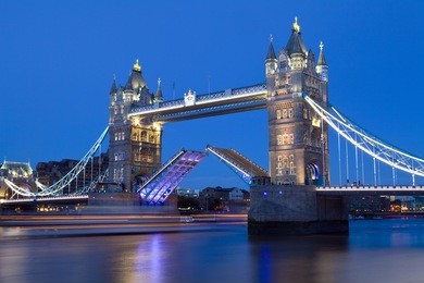 tower bridge opens to let a ship pass underneath.  