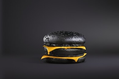 total painted in black burger with melting cheese. painted food concept poster. black friday sale. surrealism of food