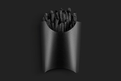 painted in black french fries with packing black. painted food concept poster on black. black friday sale. surrealism of food