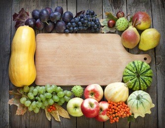 autumn fruits and vegetables and empty cutting board