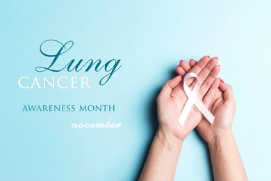 november lung cancer awareness month. female hands holding white ribbon on a blue background. 