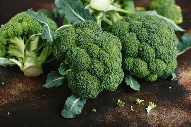 fresh green broccoli on a dark brown background. macro photo green fresh vegetable broccoli. green vegetables for diet and healthy eating. organic food.