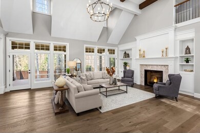 beautiful living room in new traditional style luxury home. features vaulted ceilings, fireplace with roaring fire, and elegant furnishings.