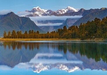 scenic view of lake matheson near the fox glacier with reflected views of aoraki mount cook and mount tasman in south island, new zealand, the place of tourist attraction and famous of new zealand.