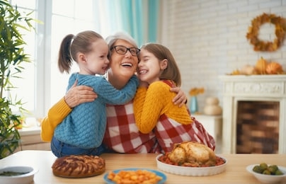 happy thanksgiving day! autumn feast. family sitting at the table and celebrating holiday. traditional dinner. grandmother and granddaughters.                               