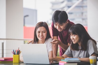 education concept - group of young people studying at the university sitting in the hall to read  book for the final exam. teenagers and friendship concepts.