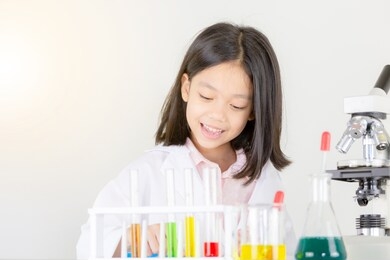 children science concept, happy little girl playing doing chemical experiments at the laboratory with white background