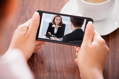 close-up of woman looking at video conference on mobile phone