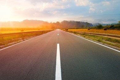 driving on an empty road to the sun