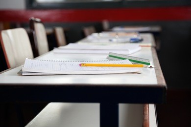 books and pencil on desk in classroom