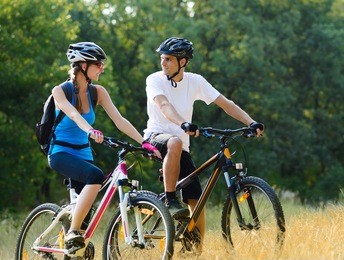 young happy couple riding mountain bikes outdoor. healthy lifestyle concept