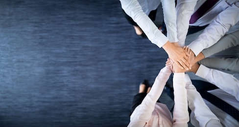 close up top view of young business people putting their hands together. stack of hands. unity and teamwork concept.
