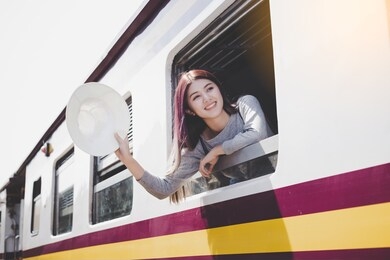 beautiful young woman saying bye bye to her family, boyfriend. attractive beautiful asian girl going to the city for working by using train or she just arrive to train station her family welcome home