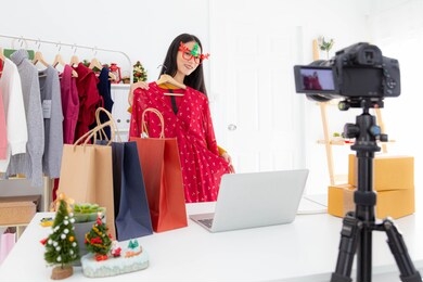 asian young women sell clothes online during christmas holidays. online business, e-commerce and christmas online shopping concept.