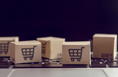 online shopping - paper cartons or parcel with a shopping cart logo on a laptop keyboard. shopping service on the online web and offers home delivery.