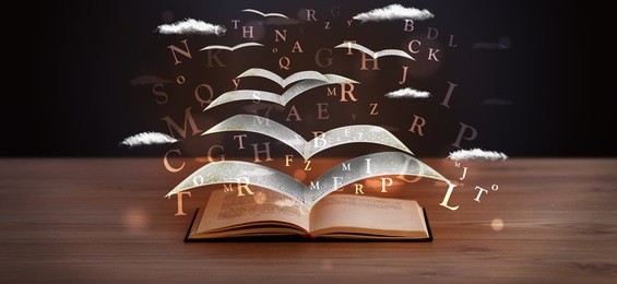 pages and glowing letters flying out of a book on wooden deck
