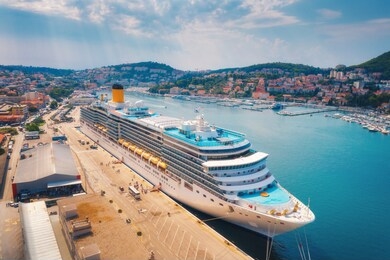 aerial view of cruise ship in harbor. top view of beautiful large ships and boats at sunny day. landscape with harbour, city, buildings, mountains, blue sea. luxury cruise. floating liner in port