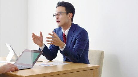 talking asian businessman in office. business meeting concept.