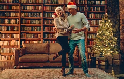 couple in love feeling happiness about their romance spending christmas or new year  together, woman and man enjoying perfect relationships and spending winter vacations in cozy home interior.