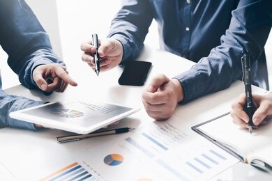 asian business adviser meeting to analyze and discuss the situation on the financial report in the meeting room.investment consultant,financial consultant,financial advisor and accounting concept

