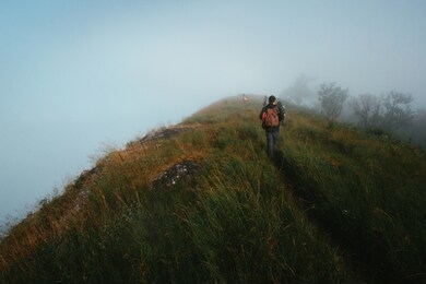 people or traveler walk on the mountain hill with grass field with sea of fog or white clouds at "doi monjong" chiangmai, thailand, asia.