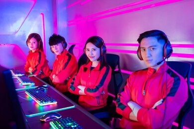 team of asian teenage cyber sport gamers smile to camera