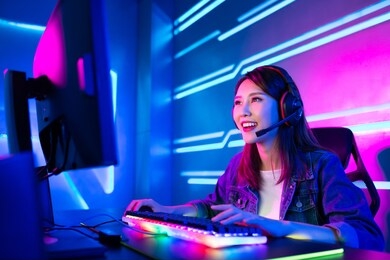 young asian pretty pro gamer having live stream and playing in online video game