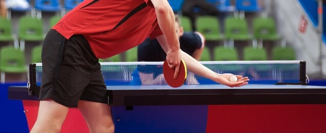 the tennis ball is in the left hand of the athlete. the tennis racket is in his right hand