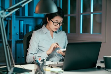 business accounting overwork deadline and people concept. asian korean woman worker with tax form and calculator working at night office. confident young lady manager wear glasses counting finance