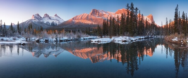 sunrise of the three sisters and the bow river from canmore near banff national park.
first snow in canadian rockies. beautiful landscape background concept. christmas time