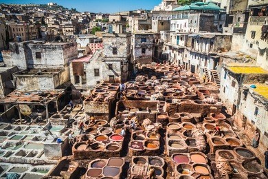 tanners working leather in the old tannery of fes, morocco