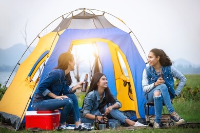 asian teenagers camping by the lake. a group of friends who drink happily. relaxation concept.