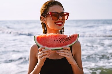 young woman with watermelon at sea