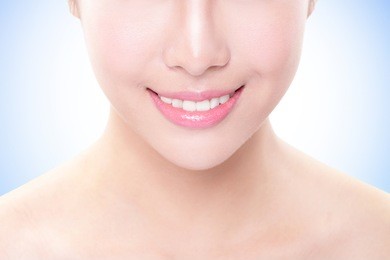beautiful young woman teeth close up with hand. isolated over blue background, asian beauty model