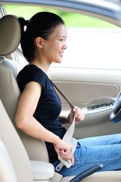 woman fasten seatbelt in a car