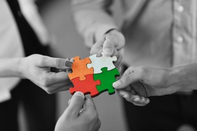 group of business people assembling jigsaw puzzle and represent team support and help concept